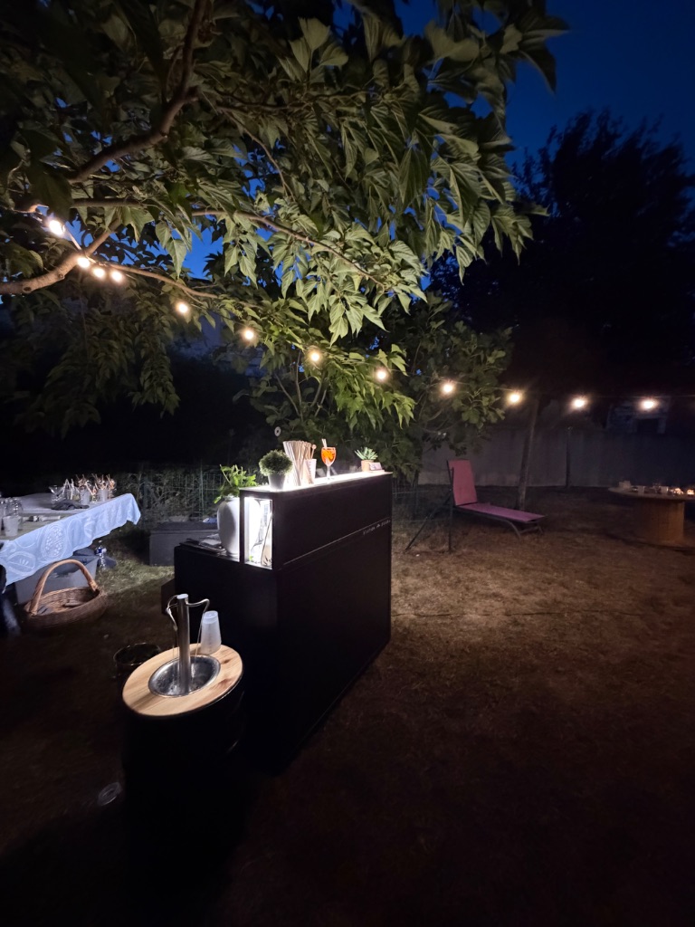 Fontaine à cocktails La Cascade en soirée sous guirlandes lumineuses